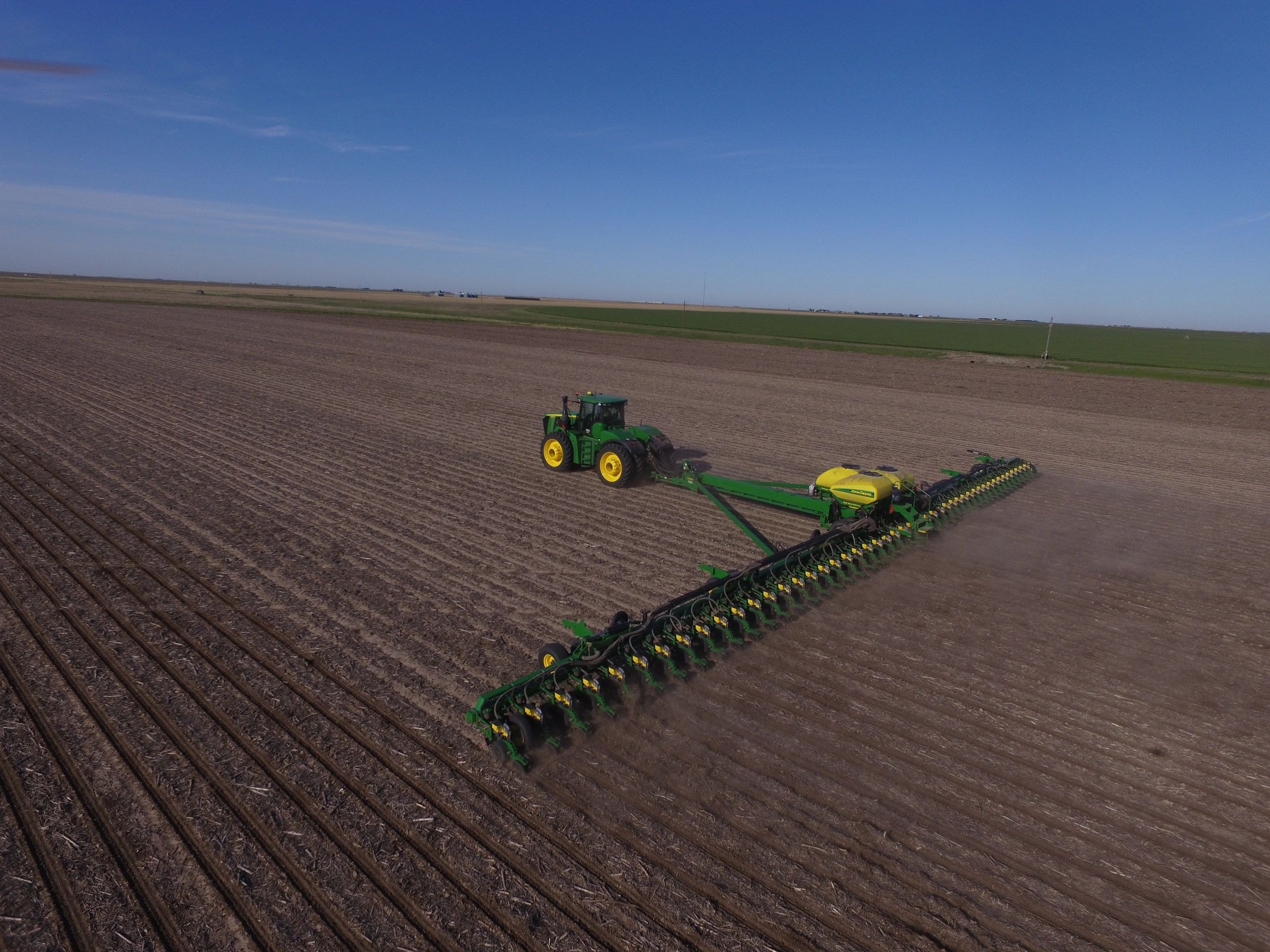 Aerial view of tractor with planter in agricultural field